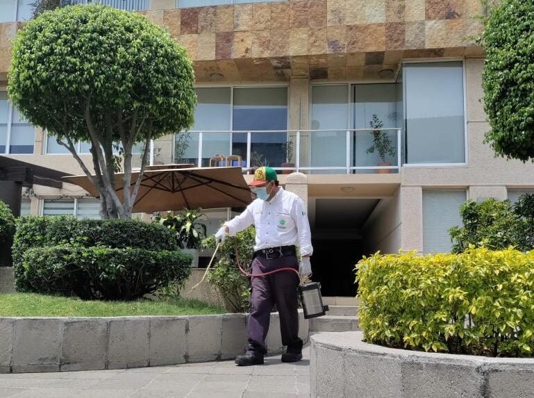 Técnico de SEPROFU realizando fumigación en una zona residencial.