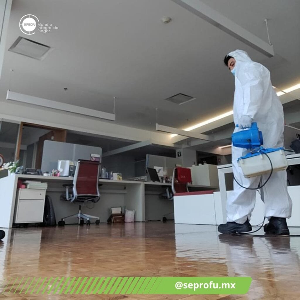 Técnico de SEPROFU realizando sanitización en sala de juntas para control integral de plagas.