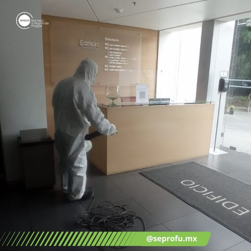 Técnico de SEPROFU sanitizando la recepción de un edificio corporativo para control integral de plagas.