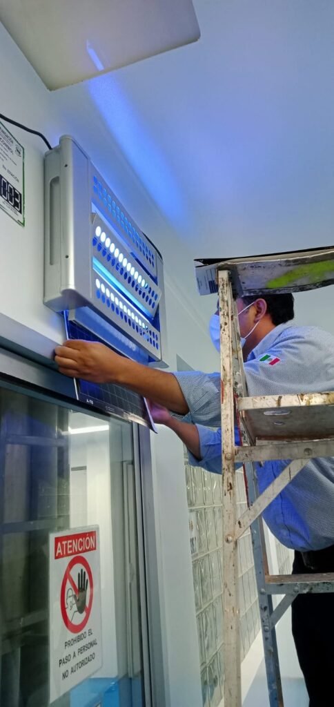 Técnico de SEPROFU realizando sanitización en sala de juntas para control integral de plagas.